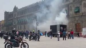 Normalistas de Ayotzinapa lanzan petardos a fachada de Palacio Nacional