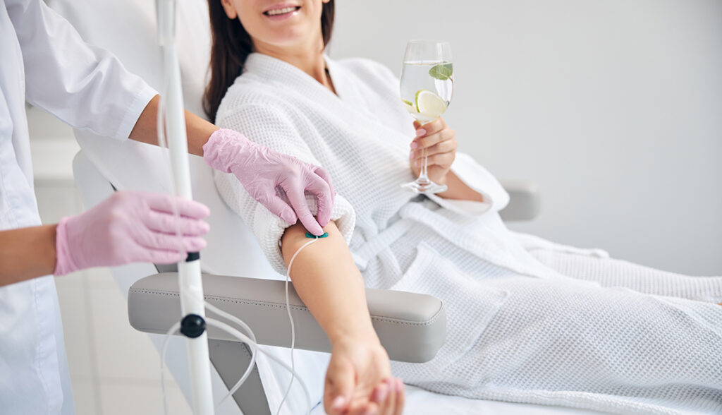 Smiling female patient undergoing intravenous vitamin therapy
